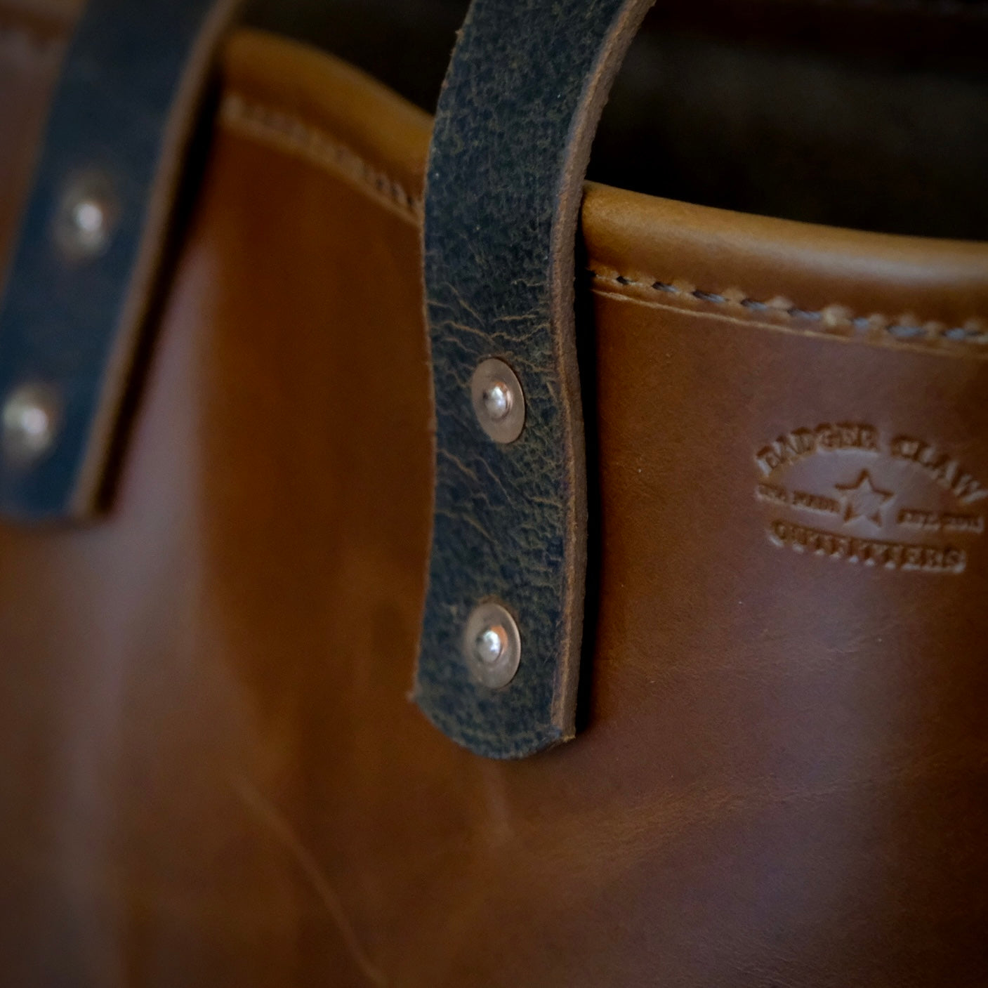 Close-up of the Hill Country Tote's premium leather straps and brass rivets, showcasing its classic design and craftsmanship.