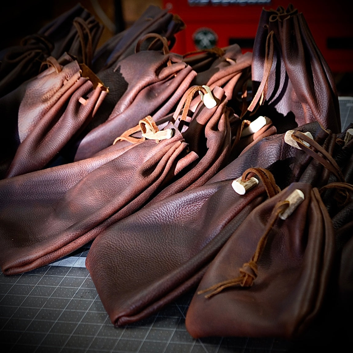 Voyageur leather drawstring pouches arranged, showcasing handcrafted quality and premium oil-tanned leather.