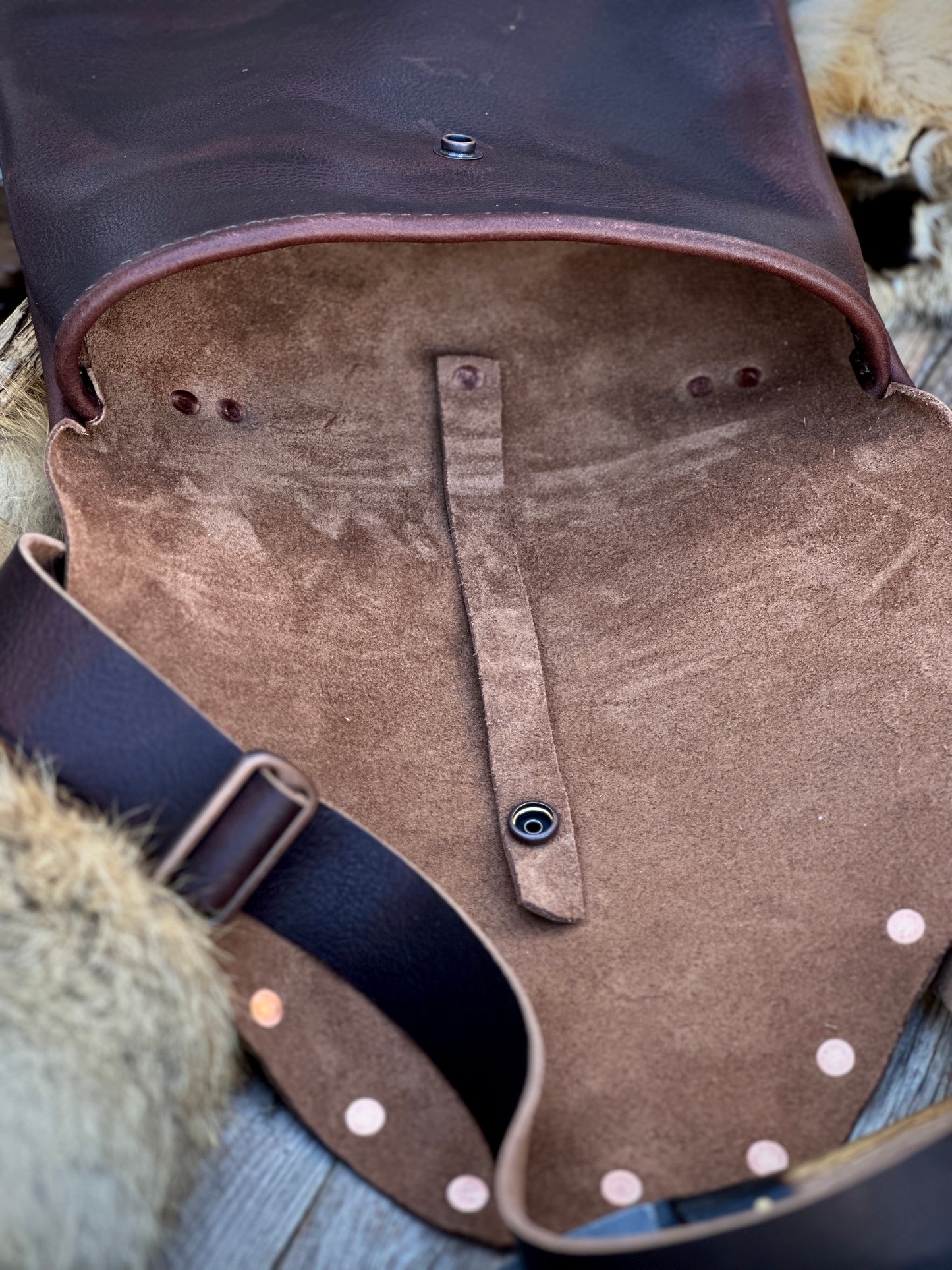Interior view of The Culper Haversack showcasing soft leather lining and decorative rivets.