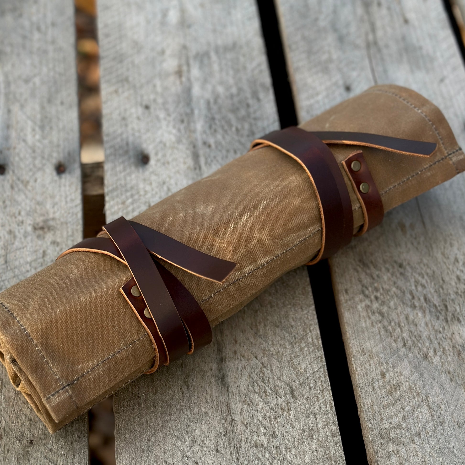 Waxed canvas knife and tool roll with leather straps, perfect for storing tools and knives up to 11 inches long.