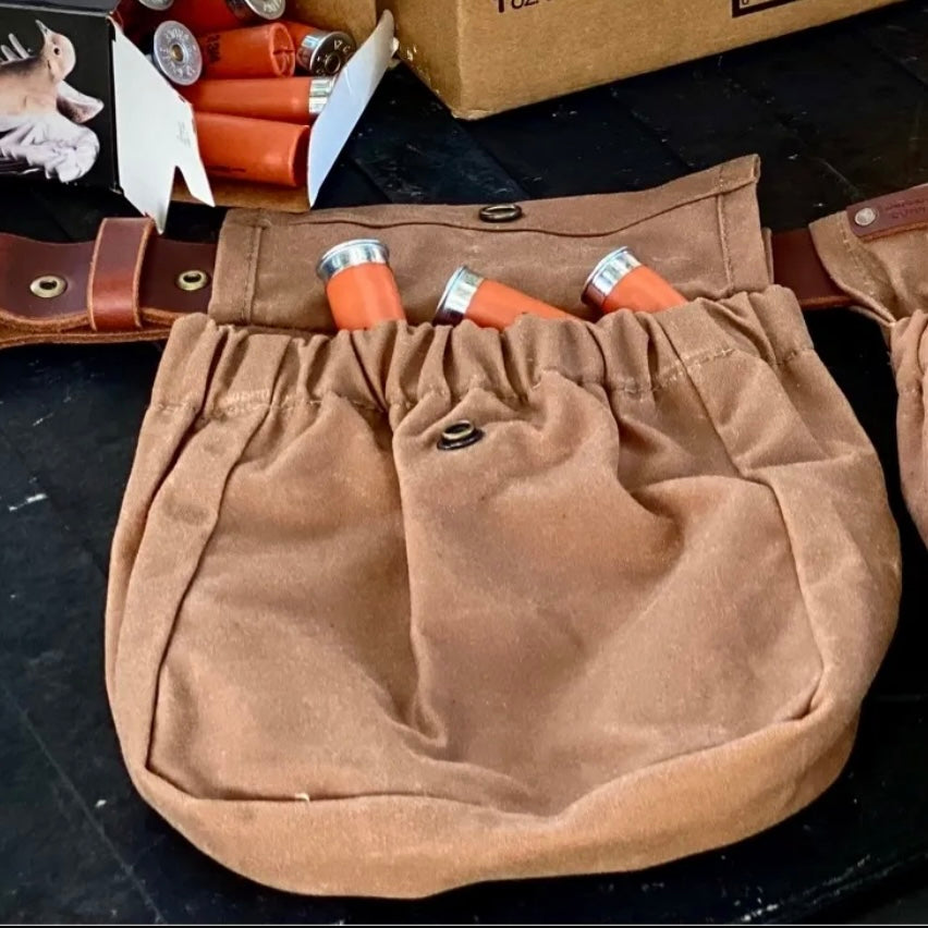 Brown shotgun shell pouch with elastic opening, showcasing shotgun shells, ideal for foraging and hunting.