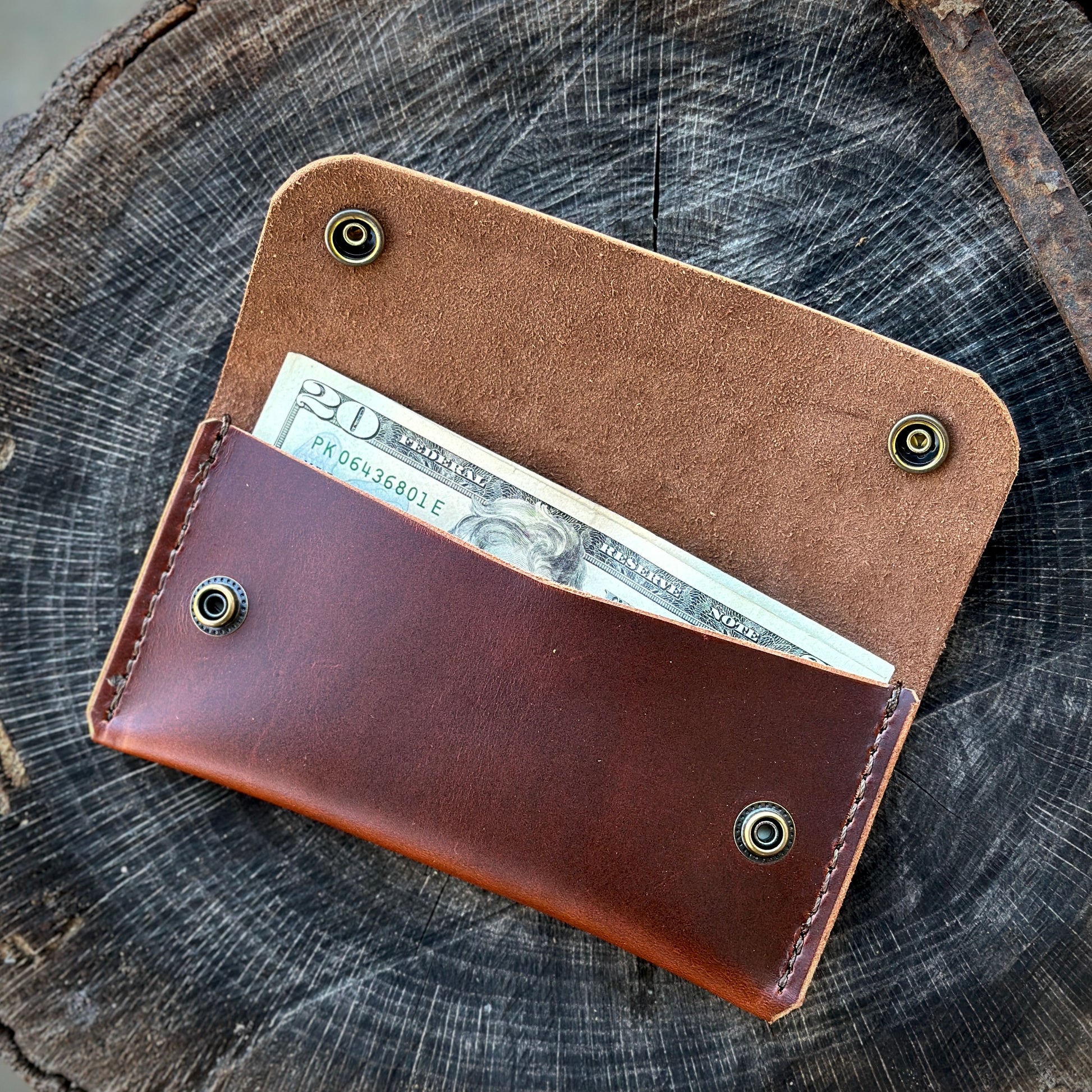 The 1690 Wallet made from premium leather, showcasing a $20 bill peeking out of its sleek design.