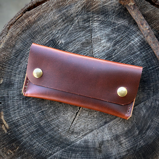 The 1690 Wallet in premium Oxford Xcel leather, showcased on a rustic wood surface.