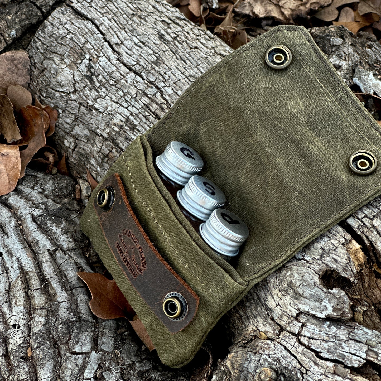 Small seasoning kit with three glass jars in a waxed canvas holder, perfect for spices and seasonings.