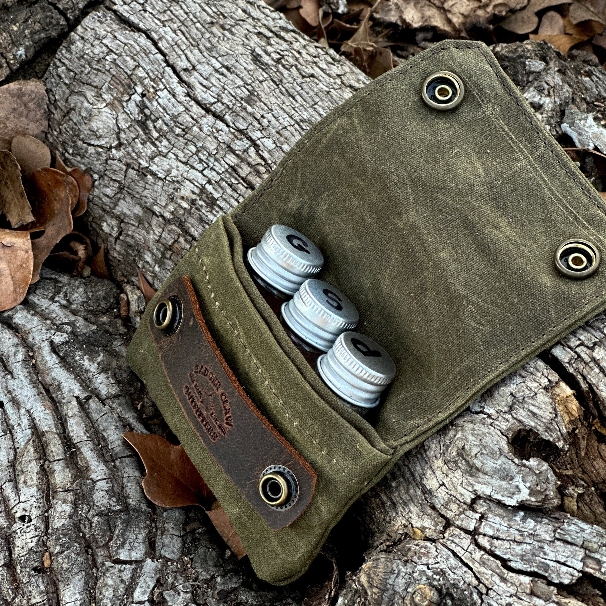 Small seasoning kit with three glass jars in a waxed canvas holder, perfect for spices and seasonings.