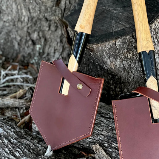 Handmade shovel mask made from premium leather, showcasing durability and craftsmanship on a rustic wooden background.